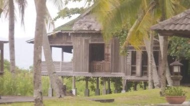 Bungalovlar, sandalyeler, masalar ve Flora. Sağdan Sola Görüntü