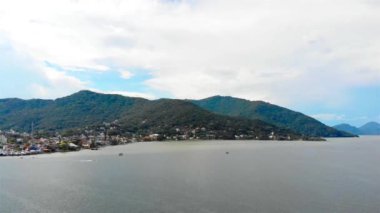 Brezilya 'da büyük bir gölün yanında evleri olan Yeşil Tepeler' in havadan görünüşü - sol doli