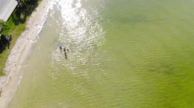 Floripa 'da kristal gibi temiz bir gölde eğlenen küçük bir ailenin en iyi hava manzarası.