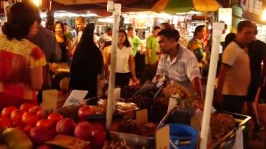Beyaz çizgili tişörtlü adam arabayı itiyor. Sola kayıyor.