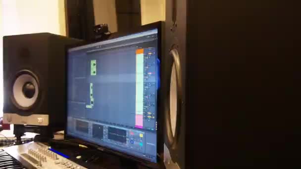 2つの黒いスピーカーの間のモニターをオンにする 録音スタジオのスライド左映像 — ストック動画