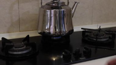 Kaynar su ısıtıcısının altındaki gaz ocağında artan ateş - orta