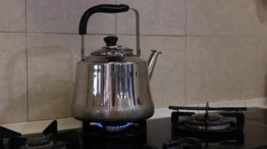 Gaz ocağında su ısıtıcısı ve düşük ısıda ateş - orta sıcaklıkta.