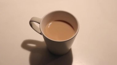 İki elinle kahve fincanı al. Kapat.