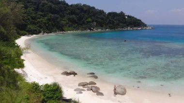 Güzel bir adadaki kıyı şeridi yakınlarındaki kayaların ve yeşilliklerin havadan görünüşü.