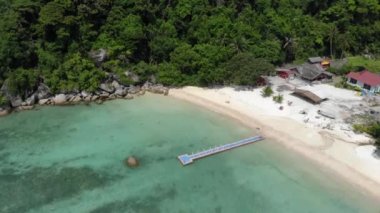 Tropikal yeşilliklerle çevrili beyaz kumsal manzarası