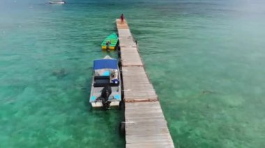 Malezya 'da bir tropik adada teknelerin ve ahşap limanın kuş bakışı görüntüsü
