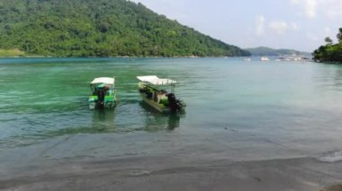 Deniz kıyısında kristal berraklığında su olan teknelerin drone görüntüsü