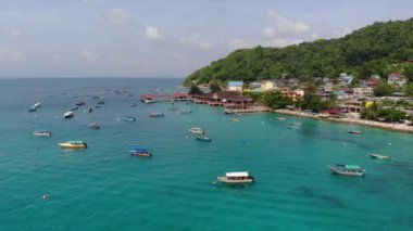 Perhentian Adası 'ndaki tropik dağların yakınındaki renkli teknelerin hava manzarası