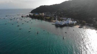 Yeşillik yakınlarındaki bir adada kristal berrak deniz suyunun havadan görünüşü