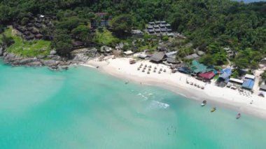 Yeşil ve dağlarla çevrili temiz su plajının havadan görünüşü