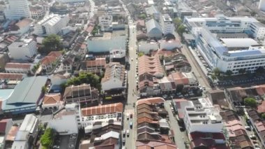 Renkli çatıları ve yoğun yolları olan evlerin havadan görünüşü geriye doğru hareket ediyor.