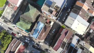 Renkli evlerin yakınındaki bir yolda ilerleyen arabaların kuş bakışı görüntüsü.