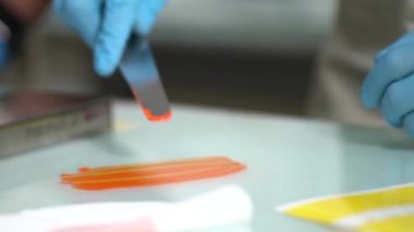 Fabrika işçisi test için turuncu boyayı sorunsuzca yayıyor.
