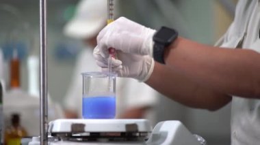 Boyacı küçük boya şişesine beyaz solüsyon ekliyor.