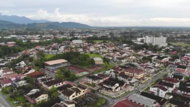 Renkli evleri çevreleyen yeşilliklerin insansız hava aracı görüntüsü - geriye doğru hareket ediyor