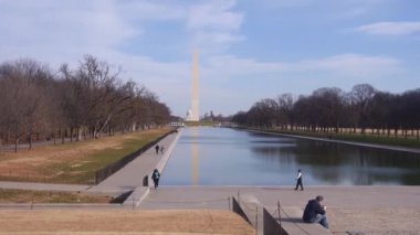 People Walking And Sitting Near Water Source And Monument - Static