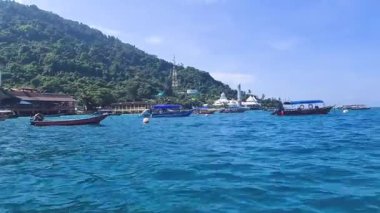 Açık bir günde, tropikal sakin bir denizde ilerleyen tekneler.