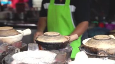 Yol kenarındaki bir dükkanda yemek yapıp satan bir adam.