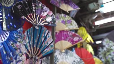 Sokak pazarındaki bir dükkanda renkli el hayranları koleksiyonu