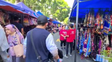 Malezya 'da kalabalık bir pazarda çok renkli kumaş dükkanları