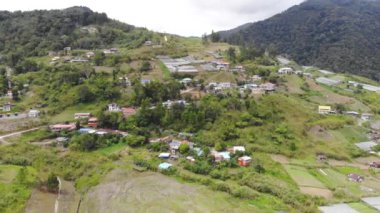Etrafı güzel yeşil dağlarla çevrili evlerin insansız hava aracı manzarası