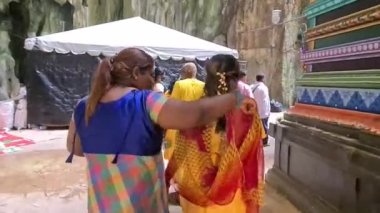 Gündüz vakti Murugan tapınağında yürüyen iki kadın.