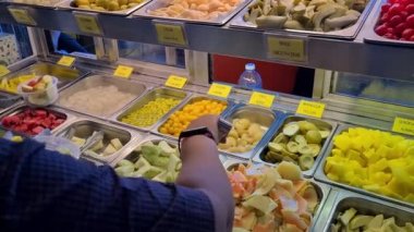 Salata barından meyve alan biri.