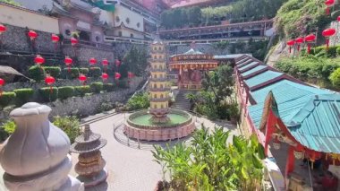 Kek Lok Tapınağı 'nın göz kamaştırıcı dış yüzeyi gün boyunca yeşilliklerle çevrili.