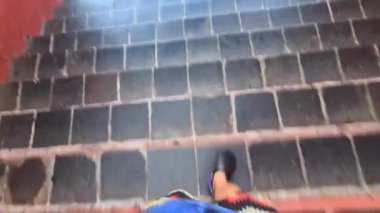 Asyalı bir adam gündüz merdivenlerden iniyor.