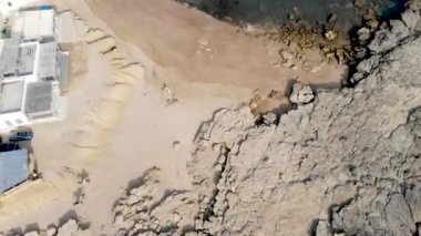 Gündüz vakti kayalık sahil şeridini gösteren insansız hava aracı manzarası.