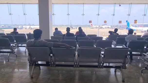 Viaggiatori Attesa Sulle Sedie Fronte Alle Piste Dell Aeroporto — Video Stock