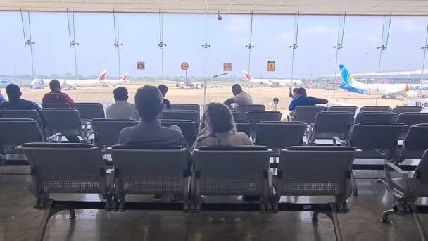 旅客在机场候机楼前的椅子上等候 — 图库视频影像