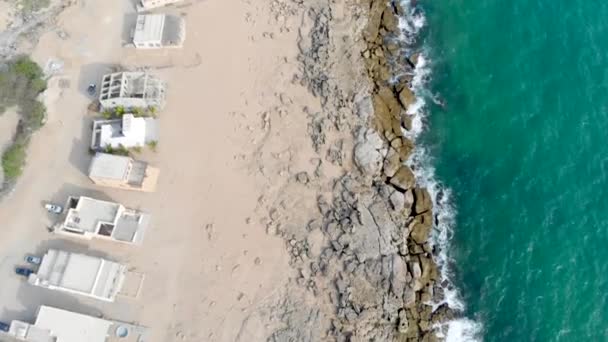近くの岩の多い海岸線の小屋の美しいドローンビュー — ストック動画