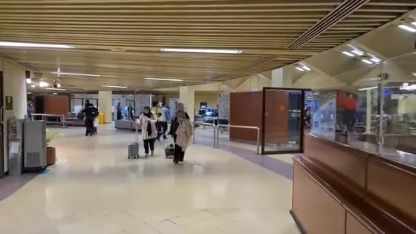スーツケースを着たアジア系女性2人が空港内を歩く — ストック動画