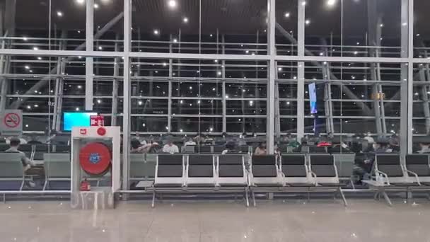 空港ターミナルの待っているエリア内に座っている旅行者 — ストック動画