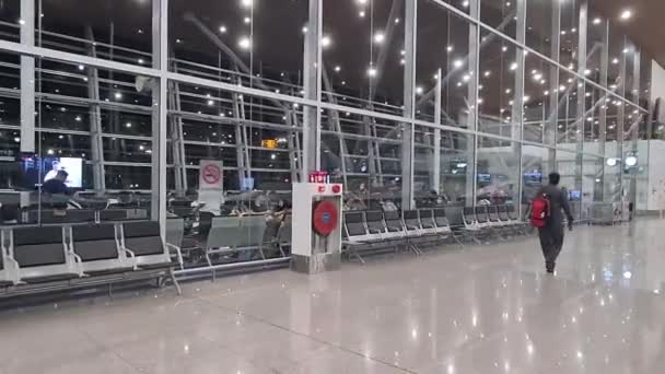 空港の空のターミナルを歩いている赤い袋の男 — ストック動画