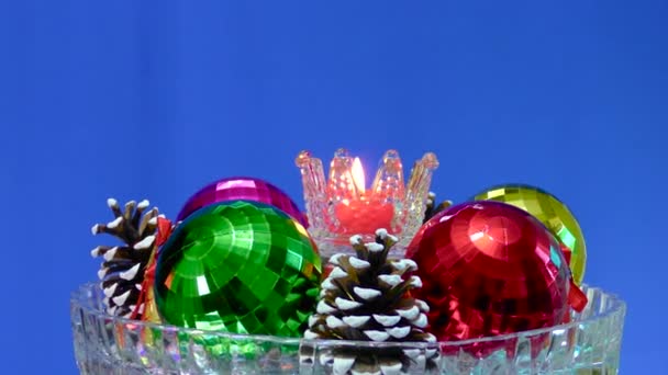 Auf Blauem Hintergrund Auf Einer Glasoberfläche Weihnachtsdekoration Eine Brennende Kerze — Stockvideo
