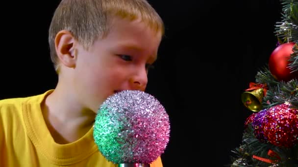 Little Boy Examines Spinning Silver Ball Decorated Christmas Tree — Stock Video