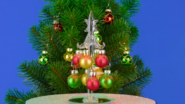 Pequeño Árbol Navidad Gira Cerca Gran Árbol Navidad Sobre Fondo — Vídeos de Stock