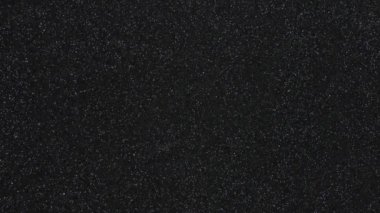 Monotonous black background in fine grain in motion from top to bottom