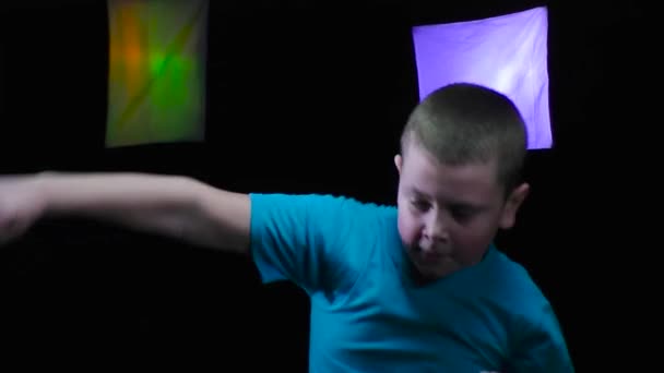 Мальчик Спортсмен Тренирует Удары Движении Черном Фоне Изменяющими Цвет Прожекторами — стоковое видео