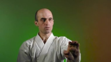 Renk değiştiren arka planda, yetişkin bir sporcu yumruk atar.