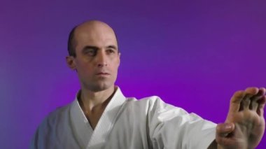 Renk değiştiren arka planda, yetişkin bir sporcu yumruk atar.