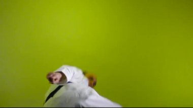 Renk değiştiren arka planda, yetişkin bir sporcu yumruk ve tekme atar.