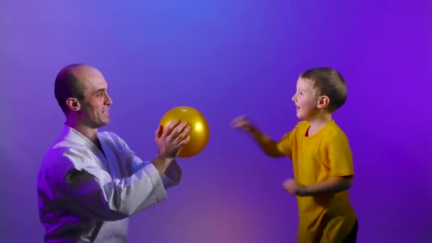 在一个变色的背景下 父子俩正在练习踢球 — 图库视频影像