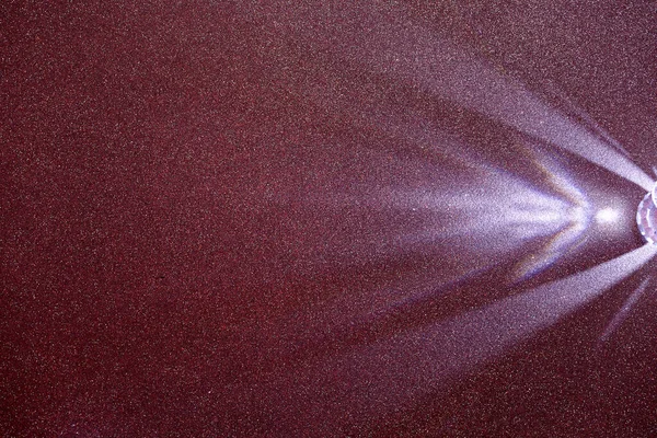 暗いライラック構造の微粒な背景では 光の薄紫散乱ビーム — ストック写真