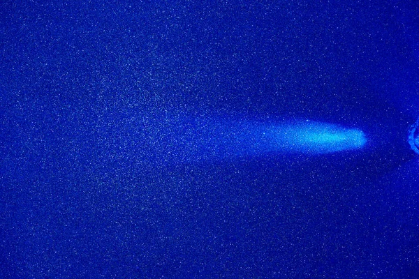 On a blue structural fine-grained background, a light blue beam of light