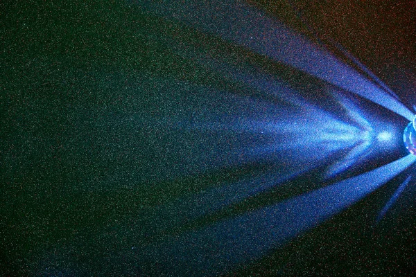 緑のグラデーションの微粒な背景に ライトブルーの散乱光ビーム — ストック写真