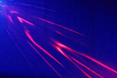 Mavi bir arkaplanda, kırmızı desenli ve aralıklı ışık huzmeleri